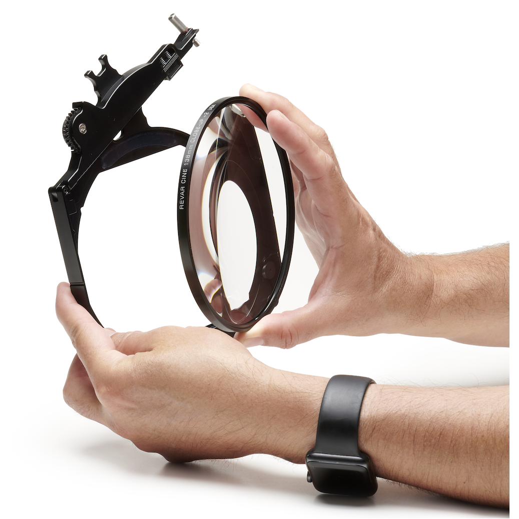 Hands placing a Revar Cine 138mm close-up diopter into a filter tray